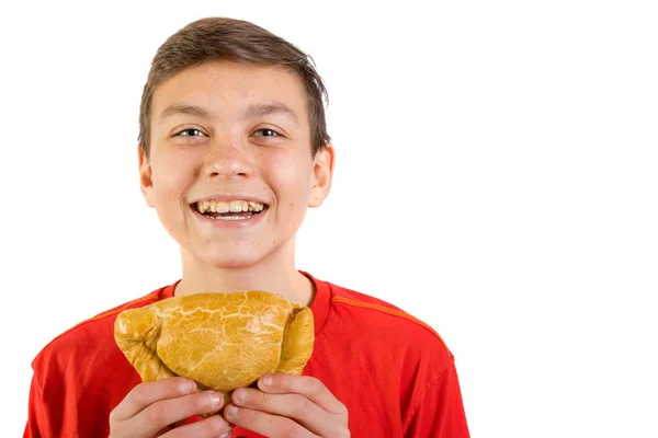 Young caucasian teenage boy eating a pasty — Stock Photo, Image