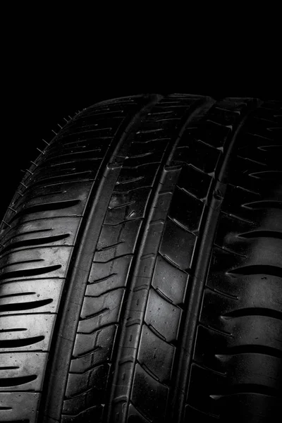 Car tyre isolated on a black background — Stock Photo, Image