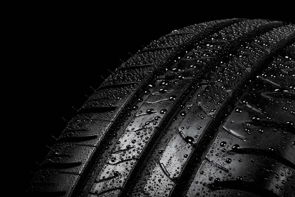 Car tyre isolated on a black background — Stock Photo, Image