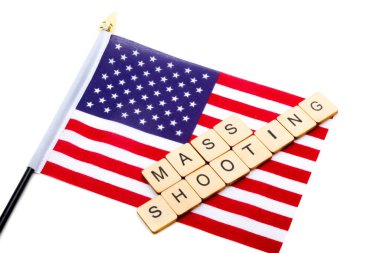 The flag of the United States isolated on a white background with a sign reading Mass Shooting