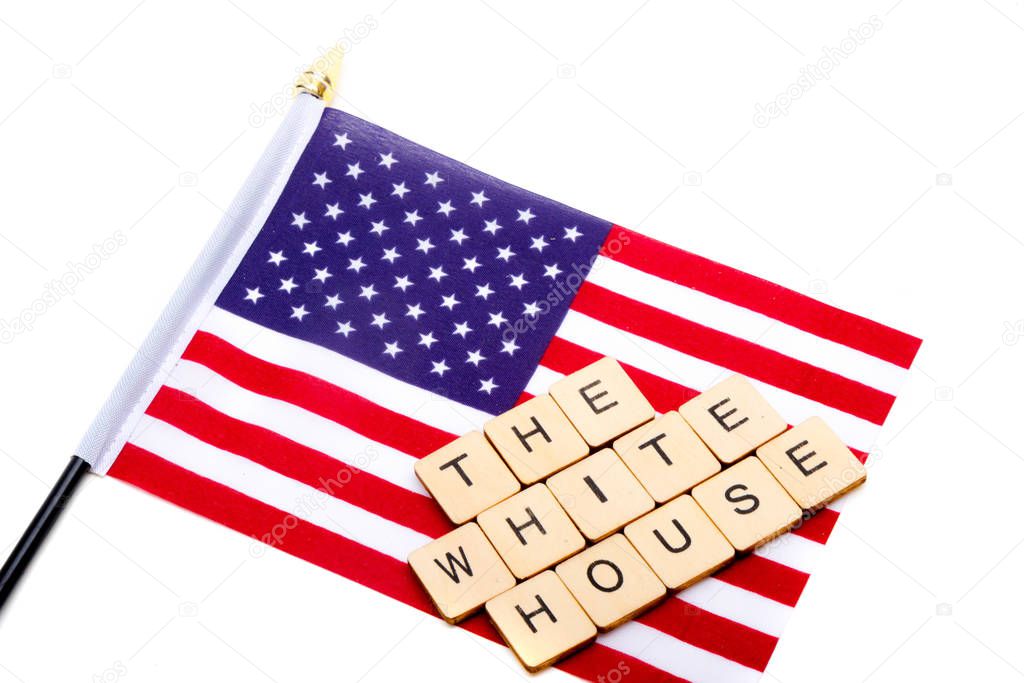 The flag of the United States isolated on a white background with a sign reading The White House