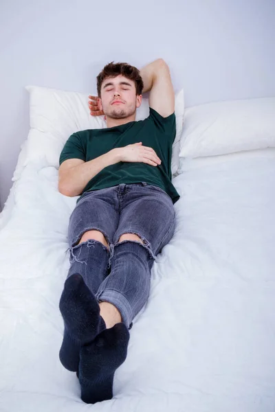 Genç Yetişkin Bir Adam Sırt Üstü Yatar Elbiseleriyle Bir Yatakta — Stok fotoğraf