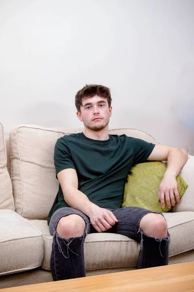 Ein Junger Erwachsener Mann Sitzt Auf Einem Sofa — Stockfoto