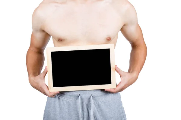 トラックスーツを着てスローガンのための黒板を保持する筋肉の若い男性大人を示す重量ルックの概念 — ストック写真