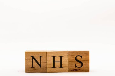 Beyaz arkaplandaki tahta blokları gösteren Coronavirus konsepti NHS