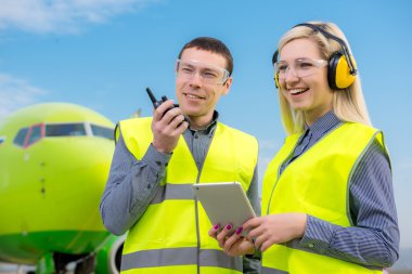 Arka planda uçak ile Havaalanı çalışanları