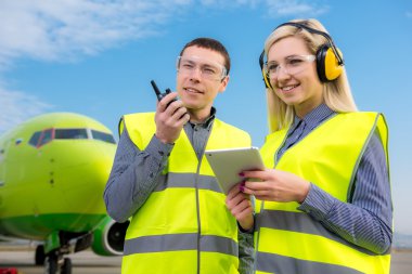 Arka planda uçak ile Havaalanı çalışanları