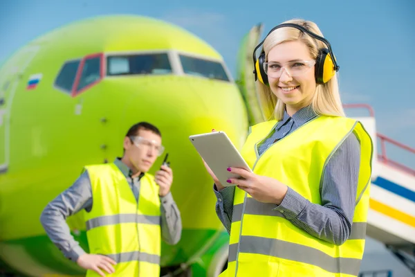 Flygplats arbetstagare med flygplan på bakgrunden — Stockfoto