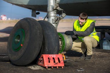 Engineer fixing aircrafts wheel clipart