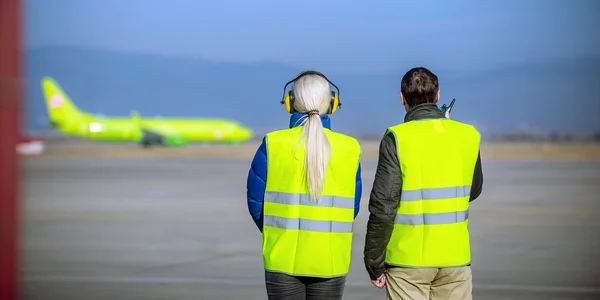 Сотрудники аэропорта смотрят на самолеты — стоковое фото