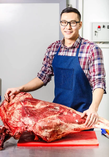 Trabalhador com carne crua — Fotografia de Stock