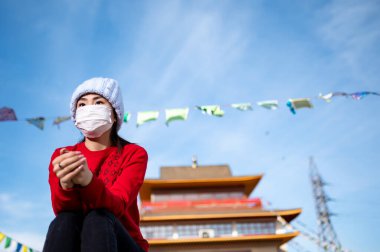 Maske takan Asya portresi halka açık bir yerde. 