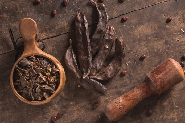 Vainas de algarroba en madera — Foto de Stock