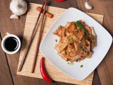 Biang Biang eriştesi biber tozu, sarımsak, taze soğan ve soya sosuyla servis edilir.