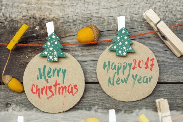 Joyeux Noël et bonne année 2017 fond de carte fabriqué à partir de guirlande artisanale de glands colorés, jouets décoratifs et un arbre de Noël en bois . — Photo
