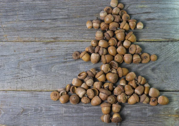 Prettige kerstdagen en gelukkig Nieuwjaar kaart achtergrond handgemaakte ambachtelijke gekleurde eikels-kerstboom. — Stockfoto