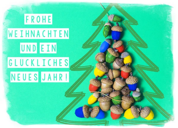 Veselé Vánoce a šťastný nový rok 2017 v německé karty. Vánoční strom vyrobený z řemesla barevné žaludy — Stock fotografie