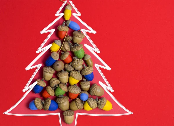 Mutlu Noeller ve mutlu yeni yıl kartı arka plan el yapımı Elişi renkli meşe palamutları Noel ağacı. — Stok fotoğraf