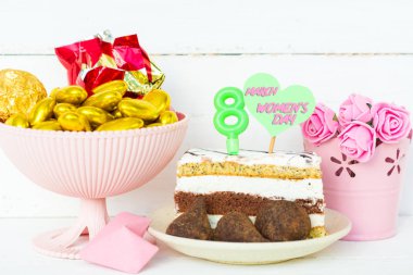 tatlı ve bir tabak bir mum ile 8, hiçbiri metin, bir buket çiçek bir kova için kalp şeklinde çikolata şekerleme. kart mutlu kadınlar günü 8 Mart günü tebrik