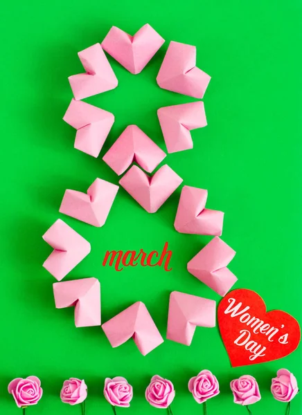 Fröhliche internationale Frauentag feiern am 8. März Karte. rosafarbene Papierherzen formen Figur acht 8 auf farbigem Hintergrund — Stockfoto
