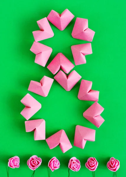 Joyeuse Journée internationale de la femme célébrer le 8 Mars CARD. rose-couleur papier coeurs forme figure huit 8 sur fond de couleur — Photo