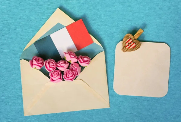 Конверт з чайної троянди, французьким прапором і серця - простір для тексту — стокове фото