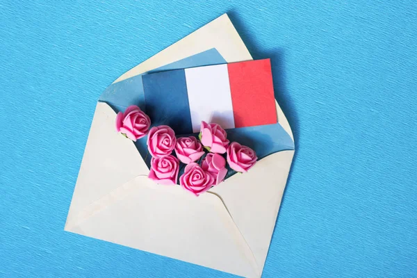 envelope with tea roses, the French flag and hearts - space for text