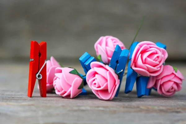 Pinces à linge en bois coloré - vision abstraite des hommes avec bouquet de roses et de femmes. Joyeuse journée des femmes salutation — Photo