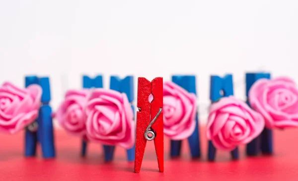 Bunte hölzerne Wäscheklammer - abstrakte Vision von Männern mit einem Strauß rosa Rosen und einer Frau. Glücklicher Gruß zum Frauentag — Stockfoto