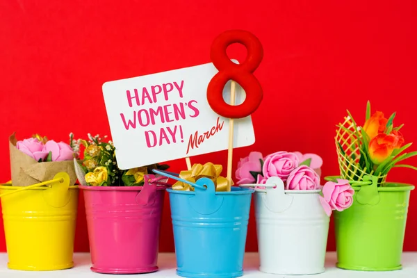 Cartão do Dia da Mulher Feliz. comemorar 8 Março de, figura forma pirulito oito 8, nota para o texto, flores em baldes coloridos . — Fotografia de Stock