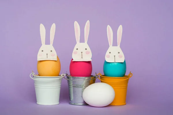 Huevos de Pascua En máscaras de conejo en cubos de colores, imagen de enfoque selectivo, Tarjeta Feliz Pascua — Foto de Stock