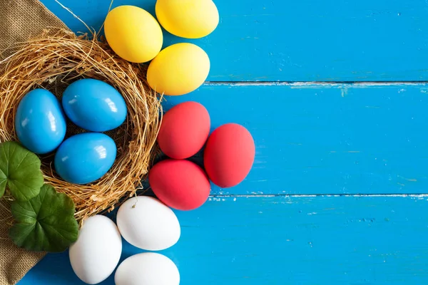 Uova colorate in nido su sfondo legno, immagine di messa a fuoco selettiva. Buona Pasqua Card - spazio per il testo — Foto Stock