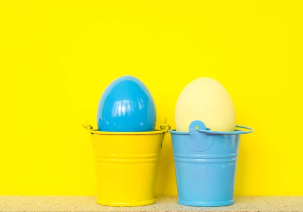 Huevos de Pascua de color azul y amarillo en cubos de colores, imagen de enfoque selectivo. Feliz tarjeta de Pascua — Foto de Stock