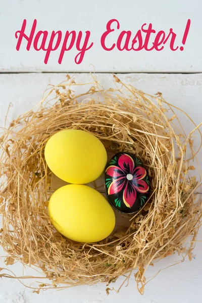 Gekleurde eieren in nest op houten achtergrond, selectieve aandacht afbeelding. Happy Easter Card - ruimte voor tekst — Stockfoto
