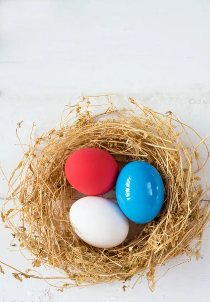 A színes tojásokat fészekben fából készült háttér, szelektív fókusz a kép. Boldog húsvéti üdvözlőlap - hely a szöveg — Stock Fotó