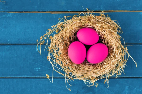 Uova colorate in nido su sfondo legno, immagine di messa a fuoco selettiva. Buona Pasqua Card - spazio per il testo — Foto Stock