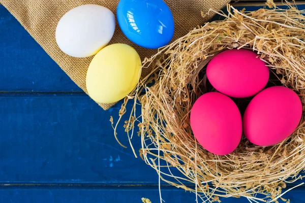 Uova colorate in nido su sfondo legno, immagine di messa a fuoco selettiva. Buona Pasqua Card - spazio per il testo — Foto Stock