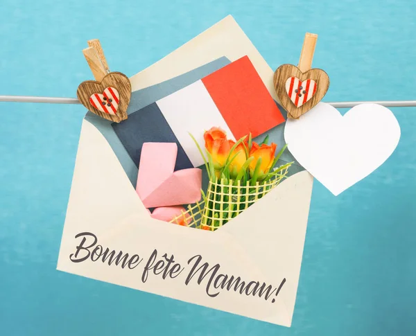 Happy Mother's Day Card in French. Envelope with paper hearts and a bouquet of flowers