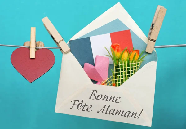 З Днем матері картки французькою мовою. Конверт папери серцем і букет квітів — стокове фото