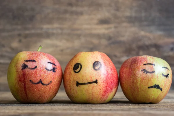 Face on an apples. Apple family on wooden background. Room for text — Stock Photo, Image