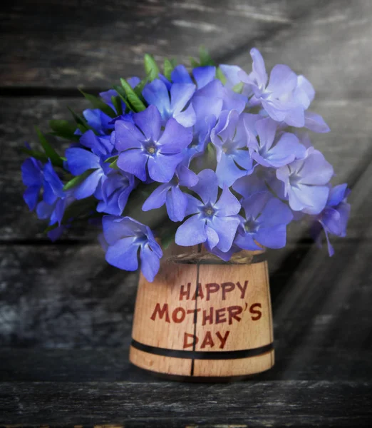 Happy Mother's Day Flower postcard. Bouquet of blue flowers on a dark background