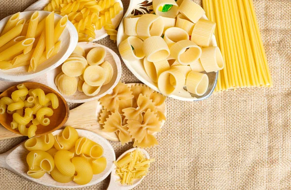 Composición de pasta italiana cruda en cucharas de madera — Foto de Stock