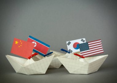 Kağıt gemi ABD bayrakları ve Kuzey Kore. Japon Denizi, kavram sevk irsaliyesi veya serbest ticaret anlaşması ve üyelik çatışma