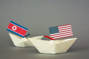 Kağıt gemi ABD bayrakları ve Kuzey Kore. Japon Denizi, kavram sevk irsaliyesi veya serbest ticaret anlaşması ve üyelik çatışma