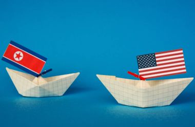 Kağıt gemi ABD bayrakları ve Kuzey Kore. Japon Denizi, kavram sevk irsaliyesi veya serbest ticaret anlaşması ve üyelik çatışma