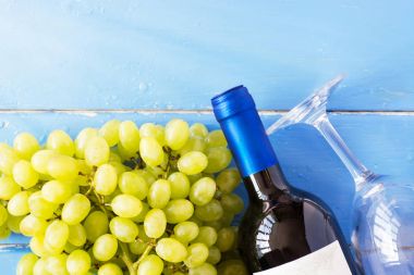 Demet taze olgun beyaz üzüm ve şarap bir mavi ahşap dokusal yüzeyinde. metin reklam alanı