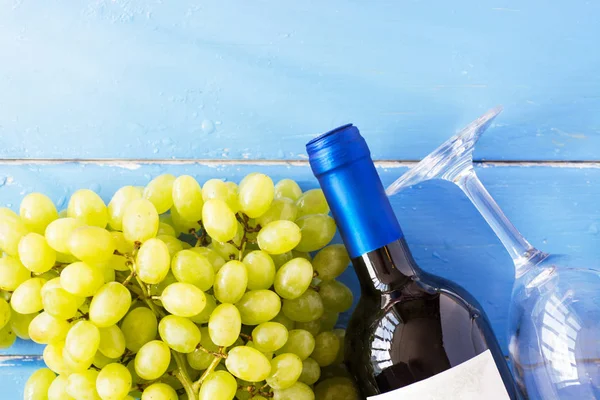 Demet taze olgun beyaz üzüm ve şarap bir mavi ahşap dokusal yüzeyinde. metin reklam alanı