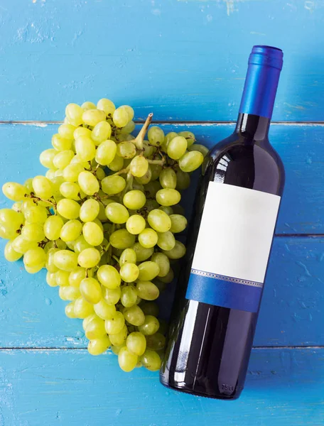 Demet taze olgun beyaz üzüm ve şarap bir mavi ahşap dokusal yüzeyinde. metin reklam alanı