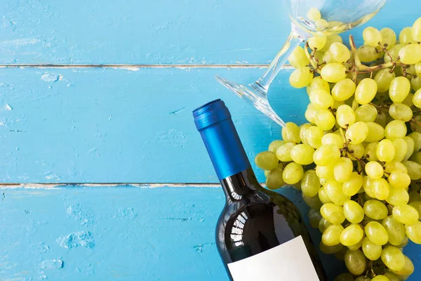 Demet taze olgun beyaz üzüm ve şarap bir mavi ahşap dokusal yüzeyinde. metin reklam alanı