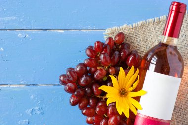 Demet taze olgun kırmızı üzüm ve mavi ahşap dokusal yüzeyi gül şarabı. metin reklam alanı